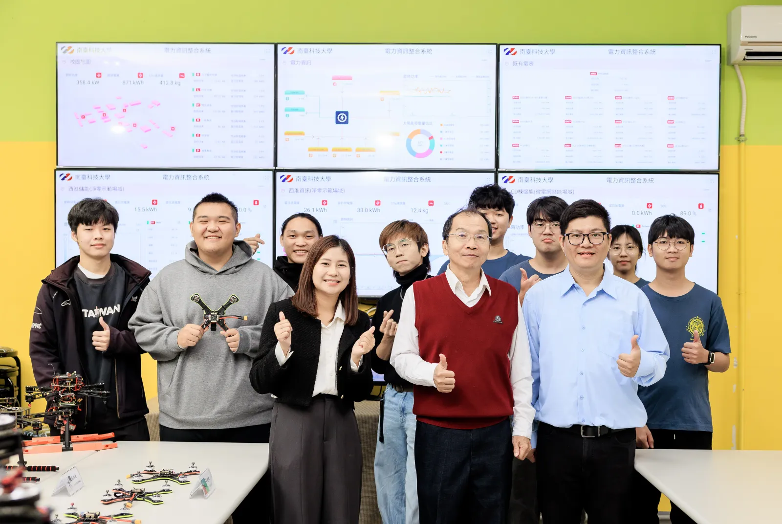 淨零浪潮下，微電網成為全球能源轉型的關鍵。南臺科大斥資上億打造「智慧微電網人才培育基地」，工學院院長蔡明村（前排中）帶領電機系黃玉君（前排左）、機械系陳宥任（前排右）等跨領域名師，攜手學生在真實運轉的場域中，淬鍊出未來的綠能實戰力 。